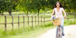 Mujer andando en bicicleta con flores