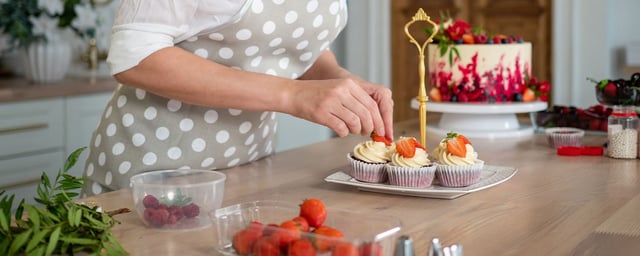 mujer decora cupcakes con fresas